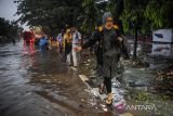 Warga menerjang genangan air yang merendam Jalan Soekarno-Hatta, Gedebage, Bandung, Jawa Barat, Senin (3/10/2022). Hujan lebat yang terjadi pada Senin (3/10/2022) sore hari membuat kawasan tersebut terendam air setinggi 30 hingga 70 sentimeter akibat sistem drainase yang buruk serta menyebabkan beberapa kendaraan roda dua dan empat mogok. ANTARA FOTO/Raisan Al Farisi/agr