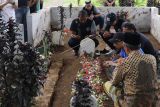 Pemain dan pelatih Arema FC berdoa di makam korban tragedi Stadion Kanjuruhan di Gondanglegi, Kabupaten Malang, Jawa Timur, Senin (3/10/2022). ANTARA FOTO/H Prabowo/Zk