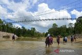 Sejumlah murid  sekolah menyeberangi sungai di lokasi pembangunan jembatan gantung kawasan pedalaman Desa Siron, Kecamatan Kuta Cot Glie, kabupaten Aceh Besar, Aceh, Selasa (4/10/2022). Kementerian Pekerjan Umum dan Perumahan Rakyat (PUPR) tahun 2022 membangun empat jembatan gantung dengan anggaran sebesar Rp12.8 miliar menggantikan jembatan lama yang rusak di sejumlah daerah pedalaman di provinsi Aceh untuk meningkatkan koneksitas antar desa dan akses ke sekolah di daerah itu, ANTARA FOTO/Ampelsa.