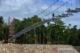 Pekerja menyelesaikan pembangunan jembatan gantung menggantikan jembatan lama yang rusak diterjang banjir tahun 2018 di kawasan pedalaman Desa Siron, Kecamatan Kuta Cot Glie, kabupaten Aceh Besar, Aceh, Selasa (4/10/2022). Kementerian Pekerjan Umum dan Perumahan Rakyat (PUPR) pada tahun 2022 membangun empat jembatan gantung dengan anggaran sebesar Rp12.8 miliar di Aceh untuk meningkatkan koneksitas antar desa dan akses warga, anak sekolah dan perekonomian masyarakat. ANTARA FOTO/Ampelsa.