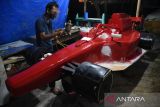 Perajin menyelesaikan pembuatan replika mobil Formula 1 (F1) yang terbuat dari barang bekas di Rumah Kreatif Anak Medan, Tegal Rejo, Medan Perjuangan, Sumatera Utara, Selasa (4/10/2022). Perajin memanfaatkan sejumlah bahan daur ulang sampah seperti stirofoam, tripleks, besi, dan karpet karet untuk diubah menjadi barang bermanfaat dan bernilai ekonomi berupa replika mobil, berbagai ornamen dan miniatur yang dijual dengan harga Rp100 ribu hingga Rp50 juta tergantung ukuran dan tingkat kesulitan. ANTARA FOTO/Fransisco Carolio