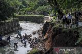 Petugas memeriksa kawasan pemakaman umum yang terdampak longsor di TPU Sirnaraga, Bandung, Jawa Barat, Rabu (5/10/2022). Hujan deras pada Selasa (5/10/2022) membuat sebagian pemakaman di TPU Sirnaraga longsor dan membuat sejumlah warga memindahkan jenazah yang masih utuh ke tempat yang lebih layak. ANTARA FOTO/Raisan Al Farisi/agr