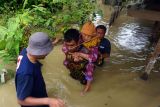 Relawan Palang Merah Indonesia (PMI) mengevakuasi seorang lanjut usia dari lokasi banjir di Kampung Baru, Lhoksukon, Aceh Utara, Aceh, Minggu (9/10/2022). Data Badan Penanggulangan Bencana Daerah (BPBD) setempat menyebutkan banjir Aceh Utara terus meluas hingga ke 15 kecamatan dengan jumlah pengungsi sebanyak 39.847 orang menyusul hujan lebat terus terjadi ditambah air kiriman dari hulu Takengon, Aceh Tengah dan Kabupaten Bener Meriah. ANTARA FOTO/Ririn/Rmd/wsj.