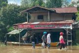  Sejumlah warga berjalan melintasi banjir di Ulak Jaya, Kecamatan Sintang, Kabupaten Sintang, Kalimantan Barat, Senin (10/10/2022). BPBD Kabupaten Sintang mengatakan tingginya curah hujan yang terjadi di Kabupaten Sintang mengakibatkan sejumlah kecamatan yaitu antara lain Sintang, Serawai, Kayan Hilir, Dedai, Binjai, Sepaok dan Tempunak terendam banjir. ANTARA FOTO/Jane Elisabeth Wuysang/jhwANTARA FOTO/JANE ELISABETH WUYSANG (ANTARA FOTO/JANE ELISABETH WUYSANG)