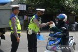 Polisi Lalulintas membagikan bu kulah atau nasi bungkus dan gulai daging kepada pengendara sepeda motor saat menggelar operasi zebra di lintas jalan nasional desa Indra Puri, Kabupaten Aceh Besar, Aceh, Selasa (11/10/2022). Operasi zebra bertema kearifan lokal dengan membagikan nasi bungkus kepada pengendaraa itu dalam rangka memperingati perayaan Maulid Nabi Muhammad SAW.ANTARA FOTO/Ampelsa.