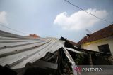  Warga memperbaiki atap rumah yang terdampak angin puting beliung di Desa Durungbedug, Candi, Sidoarjo, Jawa Timur, Rabu (12/10/2022). Puluhan rumah rusak dan beberapa pohon serta tiang listrik tumbang dan roboh akibat angin puting biung yang terjadi pada Selasa (12/10). ANTARA Jatim/Umarul Faruq/zk 