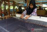 Perajin menyelesaikan pembuatan tenun kain songket di sentra perajin desa Kureng Kalee, Kecamatan Darussalam, Kabupaten Aceh Besar, Aceh, Rabu (12/10/2022). Pengusaha tenun sonket di daerah itu menyatakan produksi kain songket mulai meningkat dan dalam sebulan memproduksi 20 hingga 30 lembar kain songket dengan harga jual kisaran Rp 1,2 juta hingga Rp1,7 juta per lembar menurut kualitasnya. ANTARA FOTO/Ampelsa.