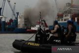 Kapal tunda (tug boat) memadamkan api yang membakar kapal kargo LIT Enterprise di Dermaga Jamrud Selatan, Pelabuhan Tanjung Perak, Surabaya, Jawa Timur, Kamis (13/10/2022). Sebanyak 15 kendaraan pemadam kebakaran dari Dinas Pemadam Kebakaran dan Penyelamatan Kota Surabaya serta PT Pelabuhan Indonesia (Persero) dikerahkan untuk memadamkan kebakaran kapal di pelabuhan itu. ANTARA Jatim/Didik Suhartono/zk 