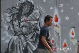 Pejalan kaki melintas di depan lukisan mural bertema tragedi Kanjuruhan di jalan Simpang Gajayana, Malang, Jawa Timur, Jumat (14/10/2022). Seni mural dan montase karya seniman Malang tersebut digambar di sejumlah lokasi sebagai ungkapan duka dan keprihatinan atas terjadinya tragedi Kanjuruhan yang menelan ratusan korban jiwa. ANTARA Jatim/Ari Bowo Sucipto/zk 