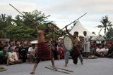 Dua warga membawa tameng dan saling memukul menggunakan kayu rotan saat tradisi Gebug Ende Seraya di Desa Seraya, Karangasem, Bali, Jumat (14/10/2022). Tradisi memohon turunnya hujan yang ditetapkan sebagai Warisan Budaya Tak Benda oleh Kementerian Pendidikan, Kebudayaan, Riset, dan Teknologi (Kemendikbudristek) serta diakui Hak Kekayaan Intelektual (HKI) oleh Kementerian Hukum dan Hak Asasi Manusia (Kemenkumham) tersebut digelar untuk pelestarian budaya dan mempromosikan pariwisata Bali. ANTARA FOTO/Nyoman Hendra Wibowo/nym.