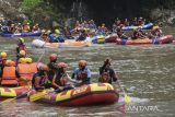 Peserta mendayung perahu saat Festival Tasik Baseuh #7 di Sungai Ciwulan, Kota Tasikmalaya, Jawa Barat, Minggu (16/10/2022). Tasik Baseuh yang digelar oleh pegiat sungai dan olahraga arus deras Republik Aer yang diikuti 30 perahu, kayak, dan 16 