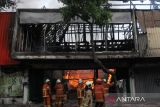 KEBAKARAN TOKO KARPET DI SURABAYA. Petugas Dinas Pemadam Kebakaran dan Penyelamatan Kota Surabaya memadamkan api yang membakar toko di Jalan Gemblongan, Surabaya, Jawa Timur, Minggu (16/10/2022). Sebanyak 18 kendaraan pemadam kebakaran dikerahkan untuk memadamkan api yang meludeskan toko yang menjual berbagai jenis karpet itu. ANTARA FOTO/Didik SuhartonoANTARA FOTO/Didik Suhartono (ANTARA FOTO/Didik Suhartono)