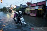 Warga mendorong kendaraannya ketika melintasi banjir di kawasan Sutojayan, Blitar, Jawa Timur, Senin (17/10/2022). BPBD Jatim mencatat sedikitnya 465 jiwa yang berasal dari 13 desa di 5 kecamatan terdampak banjir mengungsi di 12 titik pengungsian. ANTARA Jatim/Irfan Anshori/zk 