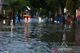 Warga melintasi banjir di kawasan Sutojayan, Blitar, Jawa Timur, Senin (17/10/2022). BPBD Jatim mencatat sedikitnya 465 jiwa yang berasal dari 13 desa di 5 kecamatan terdampak banjir mengungsi di 12 titik pengungsian. ANTARA Jatim/Irfan Anshori/zk 
