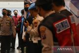 Polisi membawa tersangka bandar judi daring Apin BK (tengah) saat tiba di Bandara Kualanamu, Deli Serdang, Sumatera Utara, Senin (17/10/2022). Polri memindahkan Apin dari Bareskrim Polri di Jakarta ke Polda Sumut di Medan untuk menjalani pemeriksaan lanjutan kasus yang menjeratnya. ANTARA FOTO/Fransisco Carolio/