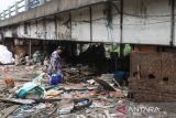 Warga membawa barang-barang saat pembongkaran bangunan liar di bawah kolong Jalan Tol Surabaya-Gempol di kawasan Lasem Barat, Surabaya, Jawa Timur, Senin (17/10/2022). Pemkot Surabaya membongkar bangunan-bangunan liar yang berada di kolong jalan tol tersebut dan memindahkan penghuninya ke sejumlah rusun di Surabaya. ANTARA Jatim/Didik Suhartono/zk 