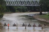 Warga menyeberangi jembatan sesek bambu di atas Sungai Bengawan Solo yang menghubungkan Desa Gadingan, Mojolaban, Sukoharjo dengan Kampung Semanggi, Pasar Kliwon, Solo, Jawa Tengah, Senin (17/10/2022). Jembatan yang dibuat secara swadaya tersebut mulai dibuka sebagai jalan alternatif bagi warga untuk mempersingkat jarak tempuh karena jembatan utama yang menghubungkan daerah setempat ditutup sementara sebab dalam proses perbaikan. ANTARA FOTO/Maulana Surya/nym.