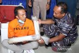 Komandan Lanudal Juanda Kolonel Laut (P) Heru Prasetyo (kanan) berbincang dengan tersangka penyelundupan benih lobster saat rilis di Mako Lanudal Juanda Surabaya, Sidoarjo, Jawa Timur, Selasa (18/10/2022).  Satuan Tugas Pengamanan (Satgas Pam) Bandara Internasional Juanda bekerja sama dengan Otoritas Bandara Juanda berhasil menggagalkan penyelundupan 29 roll plastik yang berisi  26.423 ekor benih lobster yang akan dikirim ke Singapura. ANTARA Jatim/Umarul Faruq/zk 