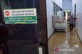 Petugas melintasi ruangan yang berlumpur dampak banjir di RSUD dr. Soedomo, Trenggalek, Jawa Timur, Rabu (19/10/2022). Banjir bandang yang merendam lantai 1 gedung lama RSUD dr. Soedomo pada Selasa (18/10/2022) menyebabkan aktivitas layanan kesehatan di rumah sakit daerah ini terganggu, terutama untuk layanan rawat jalan poliklinik. ANTARA Jatim/Destyan Sujarwoko/zk 