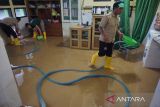 Petugas membersihkan sisa lumpur dampak banjir bandang di Ruang Poliklinik RSUD dr. Soedomo, Trenggalek, Jawa Timur, Rabu (19/10/2022). Banjir bandang yang merendam lantai 1 gedung lama RSUD dr. Soedomo pada Selasa (18/10/2022) menyebabkan aktivitas layanan kesehatan di rumah sakit daerah ini terganggu, terutama untuk layanan rawat jalan poliklinik. ANTARA Jatim/Destyan Sujarwoko/zk 