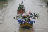 Warga menaiki perahu yang di hias dengan bendera, buah dan minuman botol di sungai Cimanuk, Indramayu, Jawa Barat, Rabu (19/10/2022). Tradisi yang digelar nelayan udang itu sebagai ungkapan rasa syukur atas hasil tangkapan udang yang melimpah dan keselamatan ketika melaut dengan ritual melarung kepala kerbau ketengah laut sebagai sesajen. ANTARA FOTO/Dedhez Anggara/agr