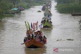 Warga menaiki perahu hias saat mengikuti Tradisi Nadran (pesta laut) di Sungai Cimanuk, Indramayu, Jawa Barat, Rabu (19/10/2022). Tradisi yang digelar nelayan udang itu sebagai ungkapan rasa syukur atas hasil tangkapan udang yang melimpah dan keselamatan ketika melaut dengan ritual melarung kepala kerbau ketengah laut sebagai sesajen. ANTARA FOTO/Dedhez Anggara/agr