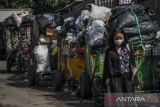 Petugas mengangkut gerobak berisi sampah di Pungkur, Bandung, Jawa Barat, Kamis (20/10/2022). Penumpukan sampah tersebut terjadi akibat akses jalan menuju TPA Sarimukti yang licin dan berlumpur sehingga menyebabkan operasional truk sampah dari berbagai wilayah di Bandung Raya mengalami keterlambatan. ANTARA FOTO/Raisan Al Farisi/agr