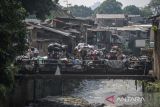 Warga melintas di samping sampah yang menumpuk di Pungkur, Bandung, Jawa Barat, Kamis (20/10/2022). Penumpukan sampah tersebut terjadi akibat akses jalan menuju TPA Sarimukti yang licin dan berlumpur sehingga menyebabkan operasional truk sampah dari berbagai wilayah di Bandung Raya mengalami keterlambatan. ANTARA FOTO/Raisan Al Farisi/agr