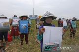 Warga yang tergabung dalam Jaringan Tanpa Asap Batubara Indramayu (Jatayu) melakukan aksi unjuk rasa di depan PLTU Indramayu, Sumuradem, Sukra, Indramayu, Jawa Barat, Jumat (21/10/2022). Aksi yang digelar dalam rangka memperingati hari Big Bad Biomass Internasional itu menuntut Pemerintah untuk melarang penggunaan palet atau serbuk kayu sebagai bahan bakar PLTU karena dianggap berpengaruh buruk bagi lingkungan. ANTARA FOTO/Dedhez Anggara/agr