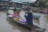 Ketua Dewan Pengawas Perum LKBN ANTARA  Widodo Muktiyo (kiri) menaiki perahu pedagang pasar terapung di Wisata Pasar Terapung Lok Baintan, Kabupaten Banjar, Kalimantan Selatan, Jumat (21/10/2022). Foto Antaranews Kalsel/Abdul Hakim/Bay.