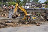 Pekerja membersihkan material kayu dan lumpur di sungai menggunakan alat berat pascabanjir bandang di lingkungan Bilukpoh, Kelurahan Tegal Cangkring, Jembrana, Bali, Jumat (21/10/2022). Sesuai data dari Badan Penanggulangan Bencana Daerah (BPBD) Kabupaten Jembrana per Jumat (21/10) terkait bencana banjir bandang tercatat sebanyak 3,957 kepala keluarga terdampak banjir bandang, sebanyak 56 rumah rusak berat, sebanyak 388 rumah rusak ringan dan jumlah kerugian mencapai 9,8 Miliar. ANTARA FOTO/Nyoman Hendra Wibowo/nym.