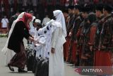 Gubernur Jawa Timur Khofifah Indar Parawansa (kiri) memberikan santunan kepada sejumlah anak saat Upacara Hari Santri di Gedung Negara Grahadi, Surabaya, Jawa Timur, Sabtu (22/10/2022). Upacara Hari Santri itu bertema Berdaya Menjaga Martabat Kemanusiaan. ANTARA Jatim/Didik Suhartono/zk 