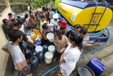 Warga antre untuk mendapatkan air bersih di Dusun Kedisan, Desa Yehembang Kauh, Jembrana, Bali, Minggu (23/10/2022). Kementerian Pekerjaan Umum dan Perumahan Rakyat (PUPR) menyalurkan bantuan 4.000 liter air bersih kepada warga di dusun tersebut karena mengalami krisis air akibat pipa saluran air putus diterjang banjir bandang yang terjadi pada Minggu (16/10). ANTARA FOTO/Nyoman Hendra Wibowo/nym.