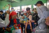 Warga membopong seorang anak yang telah menjalani khitan saat bakti sosial pemeriksaan kesehatan dan khitanan gratis bagi masyarakat desa, di SDN Cibodas, Lembang, Kabupaten Bandung Barat, Jawa Barat, Minggu (23/10/2022). Kegiatan yang diselenggarakan Pengurus Besar Ikatan Dokter Indonesia (IDI) bersama IDI Wilayah Jawa Barat dan IDI Cabang Kabupaten Bandung itu merupakan rangkaian agenda dalam memperingati HUT ke-72 IDI. ANTARA FOTO/Raisan Al Farisi/agr
