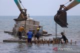 Pekerja menggunakan alat berat menyusun kubus beton pemecah ombak di Pantai Juntinyuat, Indramayu, Jawa Barat, Jumat (4/11/2022). Kementerian Pekerjaan Umum dan Perumahan Rakyat (PUPR) melalui Balai Besar Wilayah Sungai Cimanuk-Cisanggarung (BBWS) melakukan penanganan abrasi pantai yang mengancam permukiman warga di daerah itu dengan membangun tanggul geobox sepanjang 4 km. ANTARA FOTO/Dedhez Anggara/agr