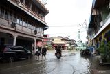 BANJIR LANDA KOTA SINGKAWANG. Dua warga berjalan melintasi genangan banjir di Kota Singkawang, Kalimantan Barat, Minggu (6/11/2022). Banjir setinggi 10 cm hingga 90 cm menggenangi sejumlah ruas jalan, pemukiman penduduk dan fasilitas umum di Kota Singkawang akibat tingginya curah hujan sejak Sabtu (5/11/2022) malam hingga Minggu (6/11/2022) di wilayah setempat. ANTARA FOTO/Reza Novriandi/jhwANTARA FOTO/REZA NOVRIANDI (ANTARA FOTO/REZA NOVRIANDI)