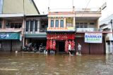 BANJIR LANDA KOTA SINGKAWANG. Dua warga berjalan melintasi banjir di Kota Singkawang, Kalimantan Barat, Minggu (6/11/2022). Banjir setinggi 10 cm hingga 90 cm menggenangi sejumlah ruas jalan, pemukiman penduduk dan fasilitas umum di Kota Singkawang akibat tingginya curah hujan sejak Sabtu (5/11/2022) malam hingga Minggu (6/11/2022) di wilayah setempat. ANTARA FOTO/Reza Novriandi/jhwANTARA FOTO/REZA NOVRIANDI (ANTARA FOTO/REZA NOVRIANDI)