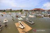 Warga memperbaiki makam kerabatnya yang rusak akibat terendam rob, di Desa Eretan Wetan, Kandanghaur, Indramayu, Jawa Barat, Rabu (9/11/2022). Banjir rob dampak gerhana bulan itu mengakibatkan puluhan rumah warga di pesisir pantai terendam setinggi 60-90 cm. ANTARA FOTO/Dedhez Anggara/agr
