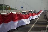 Warga memegang Bendera Merah Putih sepanjang 3.219 meter di Jembatan Suramadu sisi Madura menuju Surabaya, Jawa Timur, Kamis (10/11/2022). Pemecahan rekor MURI pembentangan Bendera Merah Putih sepanjang 3.219 meter tersebut dalam rangka memperingati Hari Pahlawan 2022. Antara Jatim/Umarul Faruq/Ds