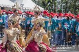 Penari mementaskan tarian dengan alat musik angklung secara bersama di halaman Gedung Sate, Bandung, Jawa Barat, Minggu (20/11/2022). Gelaran yang diikuti ratusan peserta tersebut untuk memperingati Hari Angklung Dunia sekaligus perayaan 12 tahun alat musik khas Jawa Barat tersebut diakuin sebagai warisan budaya tak benda dari Unesco. ANTARA FOTO/Novrian Arbi/agr