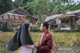 Warga berada di depan rumah yang roboh akibat gempa di Kampung Selakawung Tengah, Kabupaten Cianjur, Jawa Barat, Selasa (22/11/2022). Data dari BPBD Kabupaten Cianjur mencatat, hingga pukul 21.30 sebanyak 162 orang meninggal dunia, 326 warga luka-luka dan 13.784 warga mengungsi. ANTARA FOTO/Raisan Al Farisi/agr
