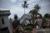 Warga menyaksikan rumah yang ambruk di Kampung Sarampad, Kabupaten Cianjur, Jawa Barat, Rabu (23/11/2022). Badan Nasional Penanggulangan Bencana (BNPB) mencatat hingga Selasa (22/11/2022) pukul 17.00 WIB, korban jiwa akibat gempa Cianjur mencapai 268 serta yang sudah terindentifikasi 122 jenazah dan korban hilang sejumlah 151 orang. ANTARA FOTO/Raisan Al Farisi/agr