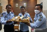 Kepala Lembaga Pemasyarakatan (Lapas) Kelas 2A Kediri Muhammad Hanafi (tengah) memperlihatkan roti tawar berisi telepon seluler yang berhasil diamankan di Kota Kediri, Jawa Timur, Selasa (22/11/2022). Petugas lapas berhasil menggagalkan penyelundupan dua buah telepon seluler lengkap beserta chargernya dalam roti tawar yang dibawa oleh seorang pengunjung untuk salah seorang narapidana kasus narkoba. ANTARA Jatim/Prasetia Fauzani/zk