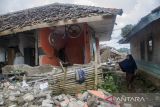 Warga melihat rumah  yang rusak terdampak gempa Cianjur di Sukamulya, Kabupaten Cianjur, Jawa Barat, Minggu (27/11/2022). Tim SAR Gabungan terus memaksimalkan pencarian korban terdampak gempa hingga memasuki waktu sepekan sejak terjadinya bencana yang telah merenggut 320 jiwa meninggal dunia. ANTARA FOTO/Novrian Arbi/agr