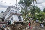 Warga melintasi area terdampak gempa di Sarampad, Kabupaten Cianjur, Jawa Barat, Minggu (27/11/2022). Tim SAR Gabungan terus memaksimalkan pencarian korban terdampak gempa hingga memasuki waktu sepekan sejak terjadinya bencana yang telah merenggut 320 jiwa meninggal dunia. ANTARA FOTO/Novrian Arbi/agr
