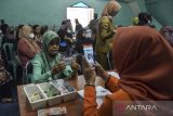 Petugas merekam kartu identitas warga dari Keluarga Penerima Manfaat (KPM) yang menerima Bantuan Langsung Tunai (BLT) saat pencairan Bansos Program Keluarga Harapan (PKH), Subsidi BBM dan BPNT di Kantor Kelurahan Maleber, Kabupaten Ciamis, Jawa Barat, Selasa (29/11/2022). Kementerian Sosial mencatat hingga November 2022 realisasi anggaran untuk belanja bantuan sosial mencapai 97,35 persen atau sebesar Rp92,96 triliun. ANTARA FOTO/Adeng Bustomi/agr