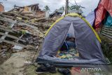 Warga beristirahat dalam tenda di area reruntuhan rumah yang rusak akibat gempa bumi Cianjur di Gasol, Cianjur, Jawa Barat, Selasa (29/11/2022). Berdasarkan data dari BNPB, hingga hari selasa (29/11) gempa bumi Cianjur menyebabkan sebanyak 30.172 unit rumah mengalami rusak berat, 108.720 orang mengungsi dan 327 orang meninggal dunia. ANTARA FOTO/Novrian Arbi/agr