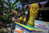 Warga merapikan hiasan sepatu dan piala 