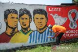 Warga membuat mural yang bergambar bintang sepakbola dunia di Permata Padalarang, Jayamekar, Kabupaten Bandung Barat, Jawa Barat, Rabu (30/11/2022). Kampung piala dunia yang dibuat secara swadaya oleh masyarakat sekitar tersebut dilakukan dalam rangka menyambut dan memeriahkan Piala Dunia Qatar 2022. ANTARA FOTO/Raisan Al Farisi/agr