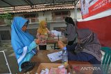 Petugas memotret warga penerima Bantuan Langsung Tunai (BLT) di Kantor Pos, Indramayu, Jawa Barat, Rabu (30/11/2022). Penyaluran BLT yang dilakukan secara serentak di kabupaten Indramayu tersebut meliputi BLT Bahan Bakar Minyak (BBM), BLT Sembako, dan Program Keluarga Harapan (PKH). ANTARA FOTO/Dedhez Anggara/agr